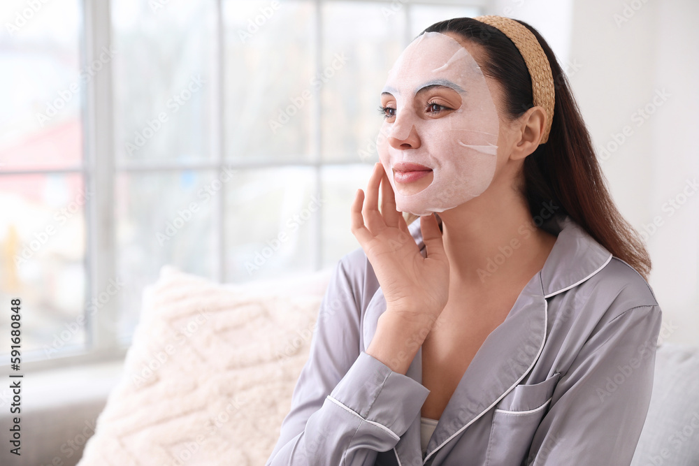 Young woman with sheet mask at home, closeup