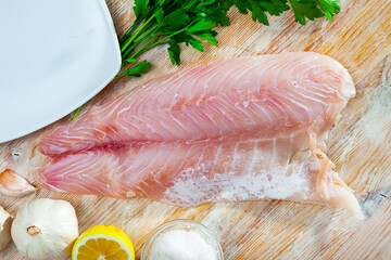 Wall Mural - Fillet of fresh raw perch fish with greens on a wooden surface, nobody