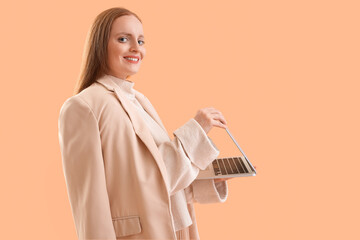 Female programmer with laptop on beige background
