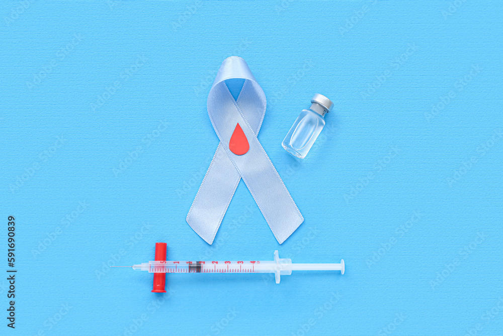Awareness ribbon with ampule and syringe on blue background. Diabetes concept