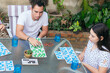 © Hector Pertuz - Family having fun playing together around a table