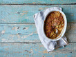 © The Picture Pantry - Top view image of potato gratin in white baking dish on wooden background with copy space