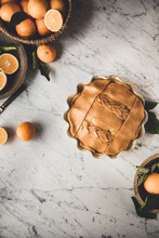Orange Pie With Decorative Pastry Top On A Marble Kitchen Surface