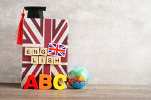 Bangkok, Thailand April 1, 2023 English Book And Piggy Bank With Globe, Learning And Tutorial For Foreigner.