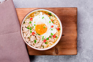 Poster - Instant noodles or ramen with minced pork and boiled egg in white bowl on the table with copy space - top view