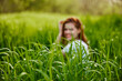 © VICHIZH - photograph of a woman sitting in the grass focusing on grass leaves
