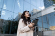 © Ivan Traimak - young brunette european woman model with a tablet on the background of the business center