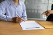 © Wasan - Female lawyer is explaining the terms of the legal contract document and asking the client to sign it properly.