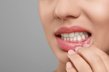 Poster - Woman showing healthy gums on grey background, closeup. Space for text