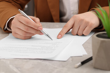 Wall Mural - Woman signing document at table, closeup view