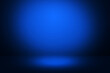 Dark blue abstract background with a glowing spotlight from the top. Modern stage design with empty space backdrop