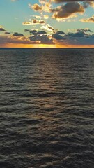Wall Mural - Aerial view of sea surface during a beautiful colourful sunset. Vertical video
