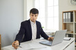 © Studio Romantic - Business man on online meeting with clients writing making notes during conversation in laptop sitting at desk in office. Modern way of doing business, communicating customers online communication.