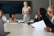 Corporate business meeting in a boardroom, with a business woman talking to her team