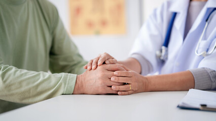 Wall Mural - Female doctor holding hands to encourage senior patient and expl