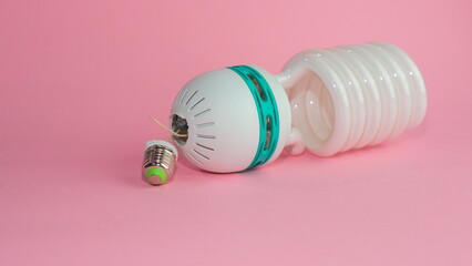 Sticker - Broken energy saving lamp on a pink pastel background