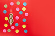 Number 8 on a red background with colored confetti. Happy birthday candles. The concept of celebrating a birthday, anniversary, important date, holiday. Copy space. banner