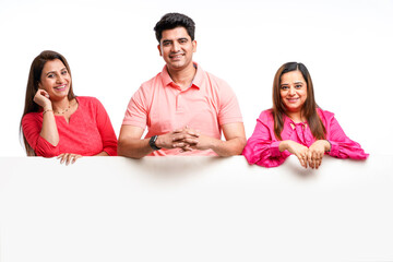 Young indian man and woman showing white board with copy space on white background.