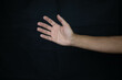 © Ahmed - hand of a scared man asking for urgent help on black background_
