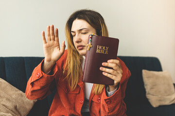 Wall Mural - A woman is holding a Bible and praying. Studying the Holy Scriptures. Spiritual growth. Faith and spirituality. Bible study and prayer. Oration.