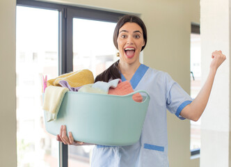 pretty young model feeling shocked,laughing and celebrating success. housekeeper and laundry concept