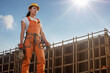 © ADDICTIVE STOCK - Generative AI image of young female construction worker in overall helmet gloves near site with building work and looking away in bright sun against blue sky