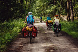 Fototapeta Sawanna - Familie fährt durch einen Wald während einer Fahrradtour durch Niedersachsen in den Sommerferien, Deutschland