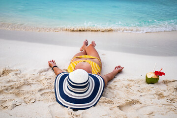 Wall Mural - woman with straw hat sunbathing on tropical beach