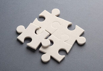 Wall Mural - White jigsaw puzzle pieces on dark background.