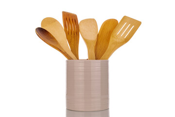 Canvas Print - Several wooden spoons for the kitchen in a ceramic dish, macro, isolated on a white background.