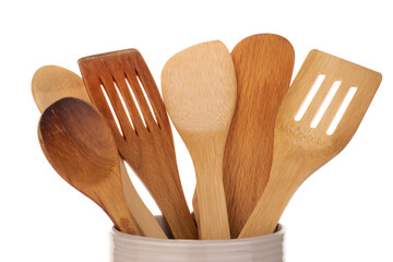 Canvas Print - Several wooden spoons for the kitchen in a ceramic dish, macro, isolated on a white background.