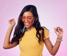 Poster - Dancing, sunglasses and cool woman excited, happy and confident isolated in a pink studio background with joy. Singing, music and young genz female dance in celebration of a party energy with glasses