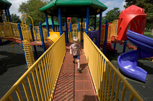 Preschooler Boy Plays On Colourful Playground Structure; Lincoln, Nebraska, United States Of America