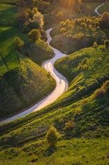 Wall Mural - Beautiful spring landscape among green hills. Charming winding road between green nature. Photo taken in Grodzisko - Stradow, Poland.