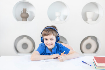 Cute school boy studying online at home. Distance learning and online education concept	