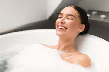 Wall Mural - Woman Closing Eyes Taking Bath With Foam In Bathroom Indoors