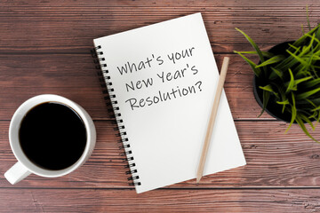 Wall Mural - Cup of coffee and notepad with text What's your New Year's Resolutions
