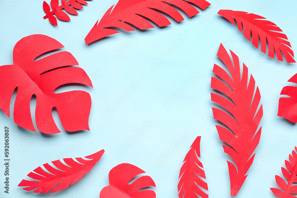 Frame made of red paper tropical leaves on blue background