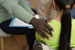 © Seventyfour - Closeup of young woman in support group circle sharing story with therapist supporting