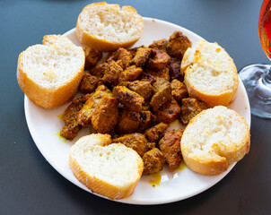 Wall Mural - Spanish cuisine, braised meat shashlik with white bread on a ceramic plate in restaurant