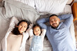 © Богдан Маліцький - asian mom and dad hug little baby girl and lie on bed, happy korean family with daughter, concept of parental love