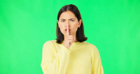 Canvas Print - Secret, green screen and face of serious woman in studio, finger and lips on background for privacy. Portrait, angry female model and silence of noise, shush on mouth and quiet for confidential emoji