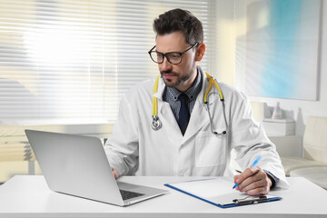 Wall Mural - Pediatrician consulting patient online at table in clinic