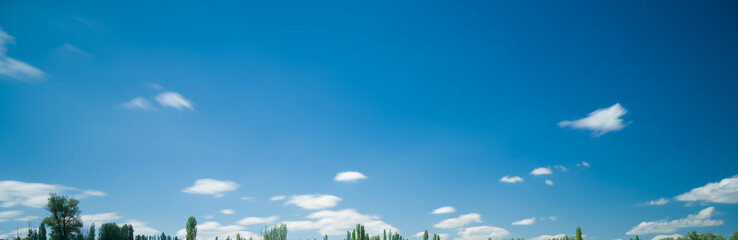 Wall Mural - Long exposure photo of white clouds in blue sky