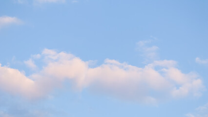 Wall Mural - blue sky background with pale pink clouds at sunset
