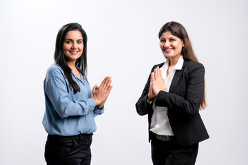 Canvas Print - Indian female managers giving namaste or welcome gesture on white background.