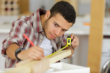 carpenter measure wooden board in his workshop