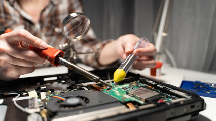 the master solders the board with a soldering iron