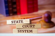 Wooden blocks with words 'State Court System'. Legal concept