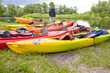 © danmorgan12 - Line of Colorful Plastic Kayaks Placed Together For Drying on Grass Outdoors.